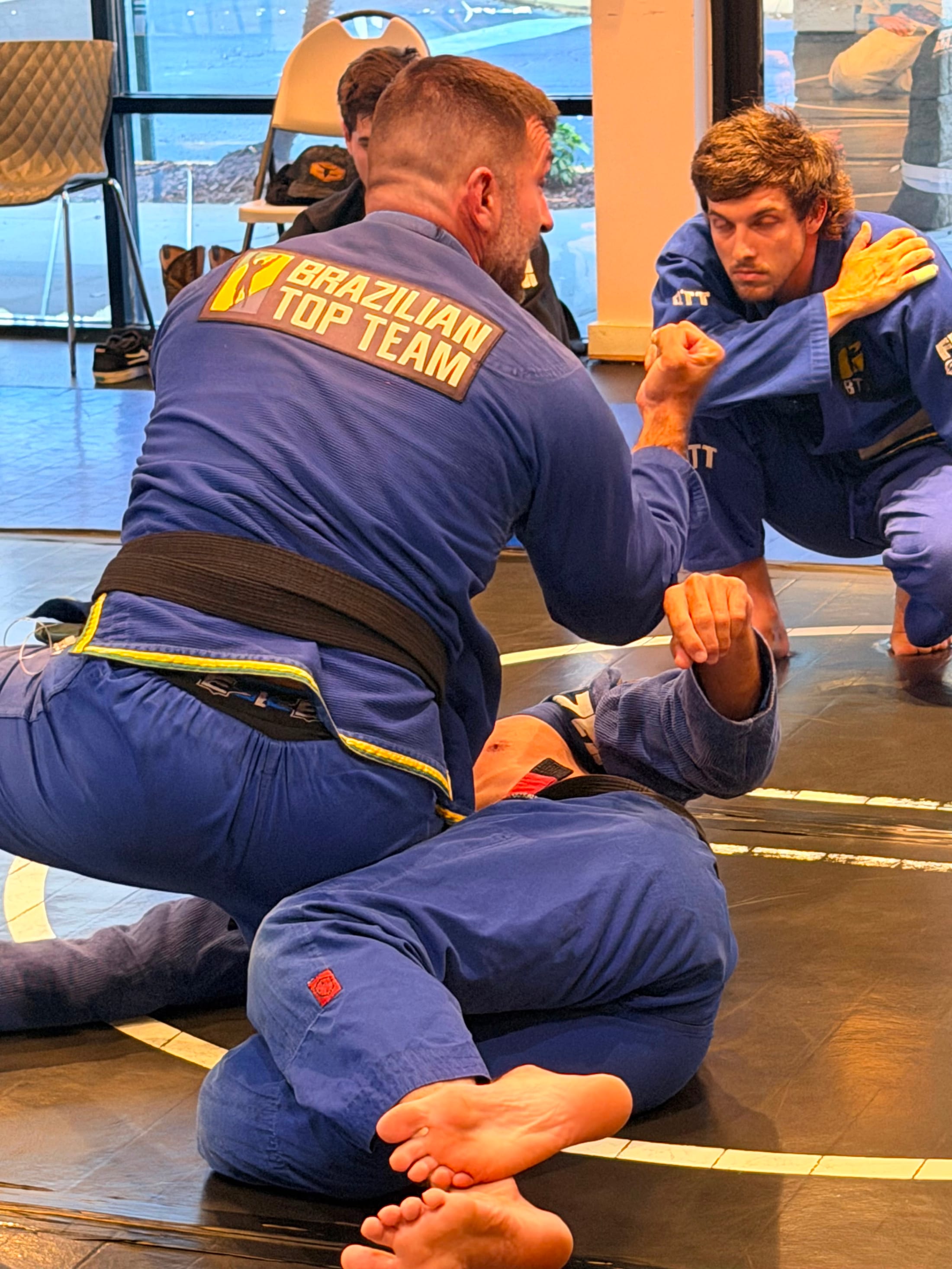 Two students drilling a jiu-jitsu position in Brazilian Top Team gis