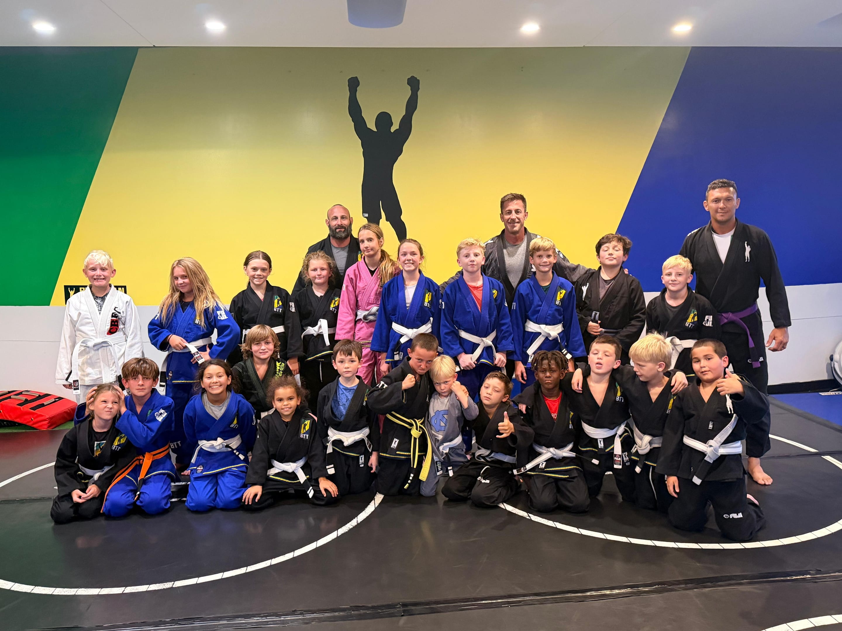 The kids class at BTT Merritt Island in front of the academy mural
