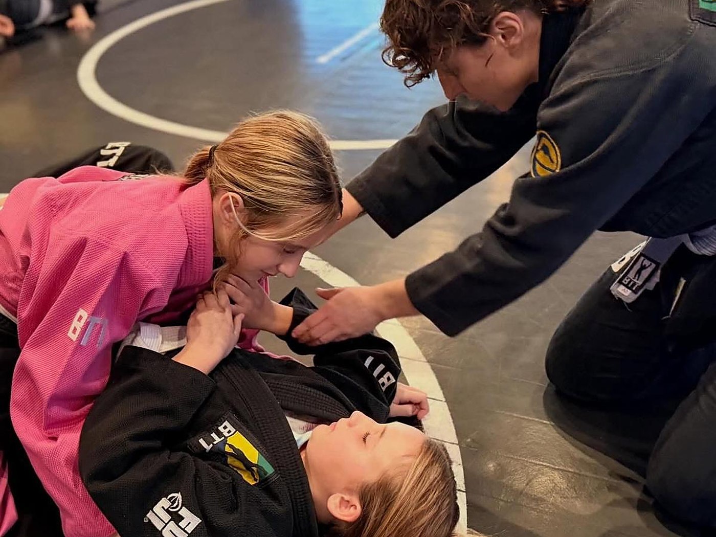 A coach guiding two students through a position at BTT Merritt Island